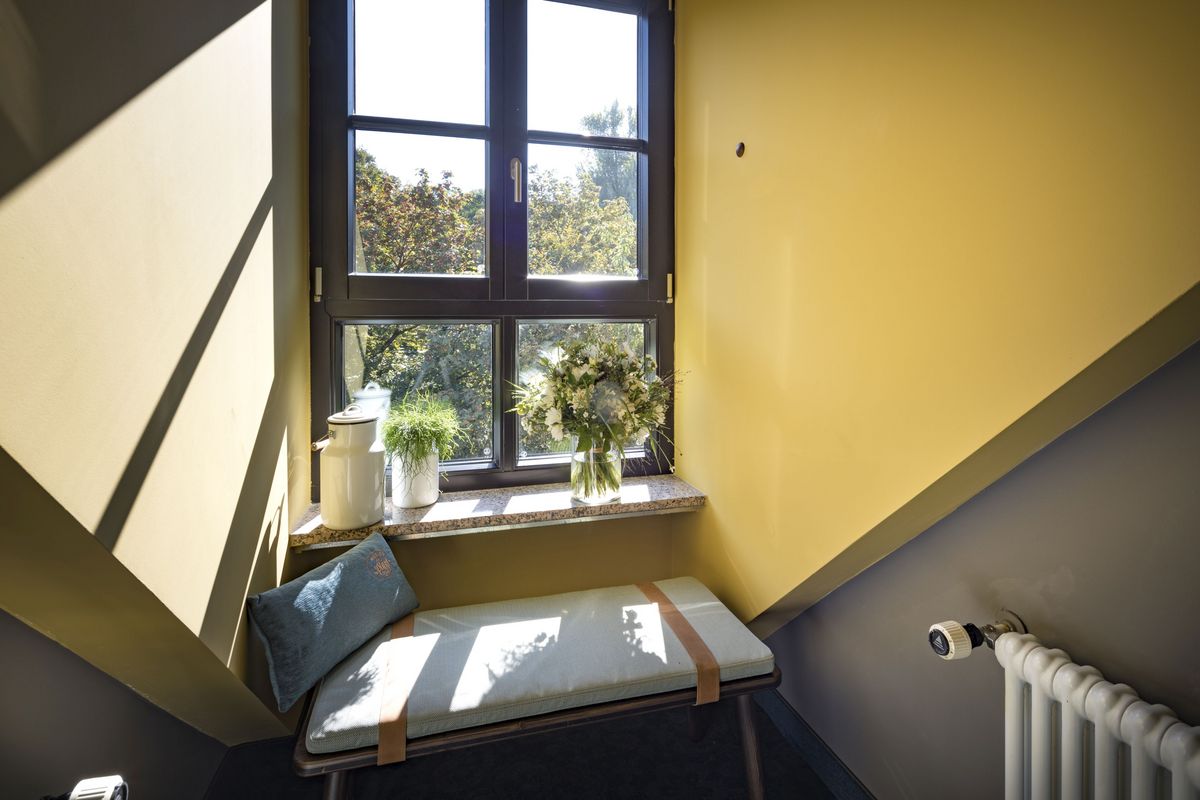 Blick aus dem Fenster, mit einem weißen Tisch, Blumen und gelber Wandfarbe im Marias Platzl Hotel München