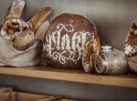 Nachhaltig produzierte Backwaren wie Brezen und Sauerteig-Brot in einem Regal.