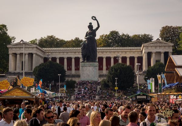 Menschenmenge vor der Bavaria-Statue beim Oktoberfest in München bei Tageslicht.