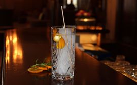 Ein Gin Cocktail im Longdrinkglas mit Orangenschale in der Bar des Platzl Hotel München