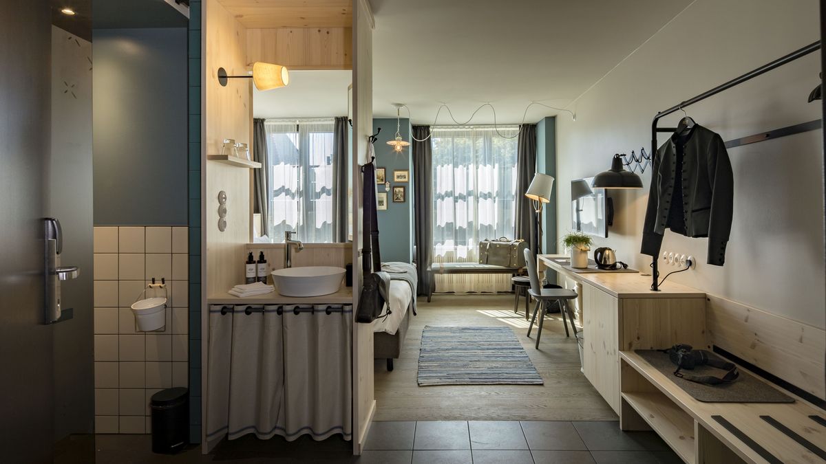 Blick in das Doppelzimmer Gundi im Marias Platzl mit Waschecke, Kofferablage, großem Fenster und Doppelbett