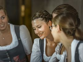 Women in traditional attitudes are sitting and engaging in conversation.