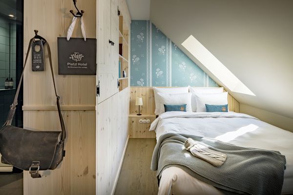 Bett im Einzelzimmer mit schräger Dachgeschoss-Wand im Marias Platzl Hotel München.