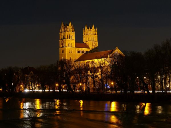 Ein Bild der stimmungsvoll beleuchteten Kirche St. Maximilian in München bei Nacht