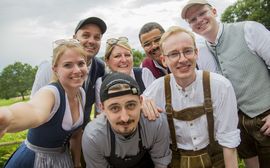 Selfie von jungen Platzl-Mitarbeitern, alle in traditioneller Tracht, eine Mischung aus Männern und Frauen
